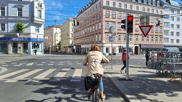 Radfahrerin wartet vor roter Ampel.
