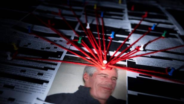 Eine Fotografie von Jeffrey Epstein ist mit rotem Faden und Reißzwecken auf einer Tafel befestigt.