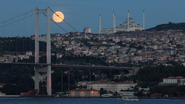FILE PHOTO: Moon rises behind the Bosphorus Bridge in Istanbul