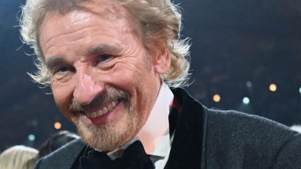 Thomas Gottschalk lächelt mit Fliege und Sakko, eine goldene Statue in der Hand.