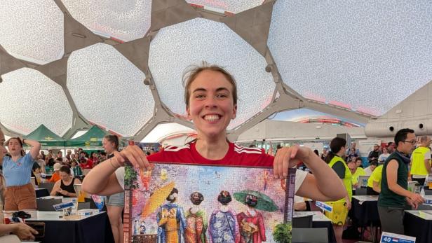Simone Reicht, Team-Staatsmeisterin im Speed Puzzeln, hält stolz ihr fertig gestelltes Puzzle im Einzelbewerb der Weltmeisterschaft hoch
