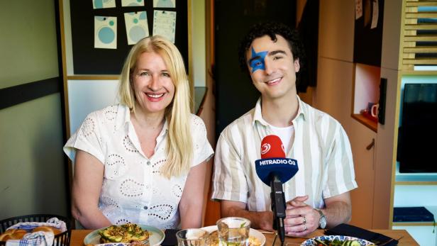 Claudia Stöckl und Cosmó sitzen am gedeckten Frühstückstisch