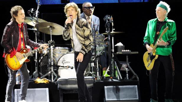 Mick Jagger singt mit Bandkollegen auf der Bühne.