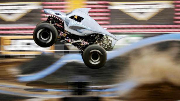 Ein Monster Truck im Hai-Design springt über eine Rampe.