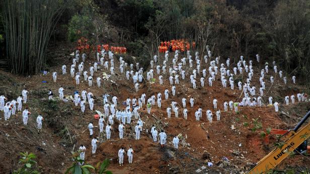 FILE PHOTO: Rescue workers stand in a silent tribute to mourn plane crash victims in Wuzhou