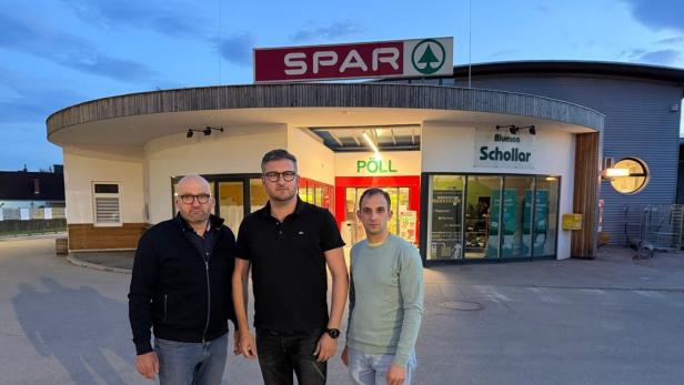 Drei Männer vor einer Spar-Filiale.