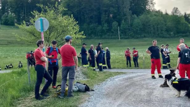 Mehrere Einsatzkräfte auf einer grünen Wiese.