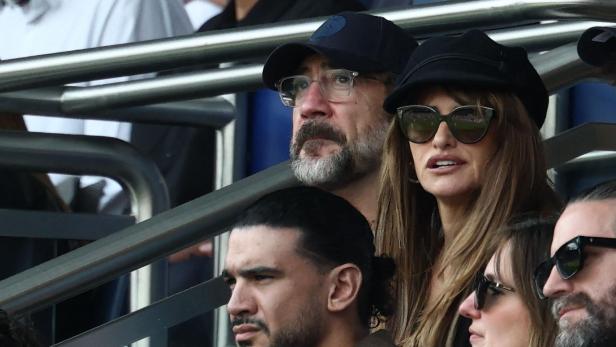Javier Bardem und Penélope Cruz schauen mit anderen Zuschauern ein Spiel.