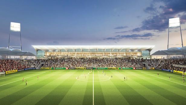 Ein Fußballstadion ist mit Zuschauern gefüllt, während ein Spiel auf dem grünen Rasen stattfindet.