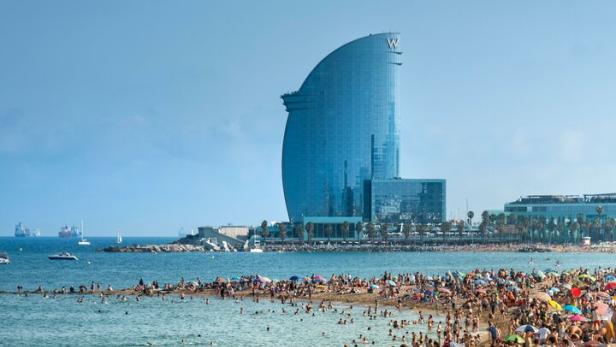 Ein Strand in Barcelona mit einem bekannten Hotel im Hintergrund