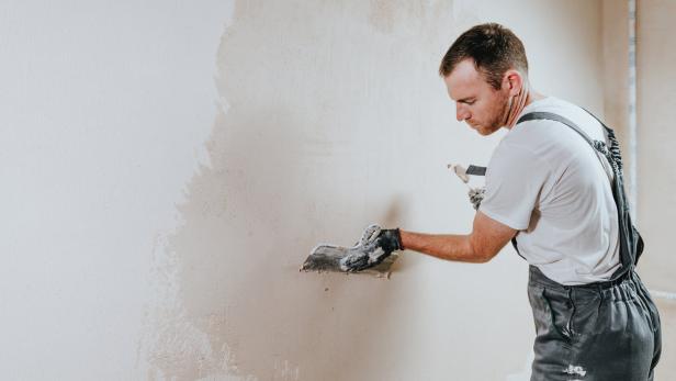Arbeiter verputzt Wand