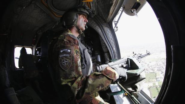 An Italian airforce gunner of the International Security Assistance Force (ISAF) aims his weapon on a CH-47 Chinook during a flight over Herat June 20, 2013. REUTERS/Fabrizio Bensch (AFGHANISTAN - Tags: POLITICS MILITARY TRANSPORT)