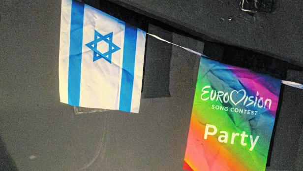 Eine israelische Flagge hängt neben einer bunten Fahne mit der Aufschrift „Eurovision Song Contest Party“.