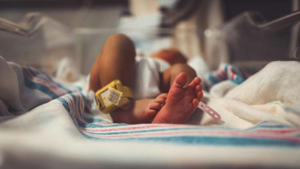 Baby liegt auf dem Bett