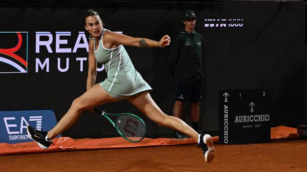 Aryna Sabalenka spielt einen Ball zwischen ihren Beinen durch.