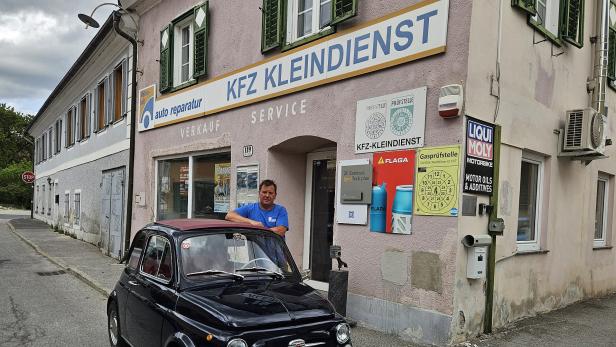 Ein Auto mit einem Mann vor einem Haus 