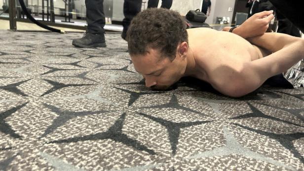 Law enforcement personnel detain Cole Tomas Allen, a suspect in the shooting incident at the White House Correspondents' Association dinner, in Washington