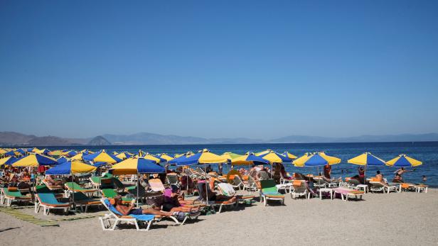 FILE PHOTO: Tourists relax on the beach of Mediterranean Sea at the island of Kos, Greece
