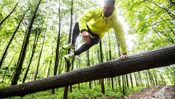 Adult Man Running in Forest in Bad Weather
