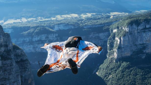 Basejumper springt in Abgrund vor Bergpanorama