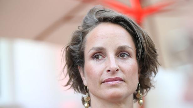 Lara Joy Körner mit kurzen gewellten Haaren blickt nachdenklich nach links.