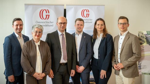 Sechs Personen in Businesskleidung stehen nebeneinander vor zwei Roll-ups mit dem Logo des Österreichischen Gemeindebundes.