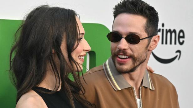 Pete Davidson mit Sonnenbrille und Elsie Hewitt schauen sich vor einem "Prime"-Logo an.