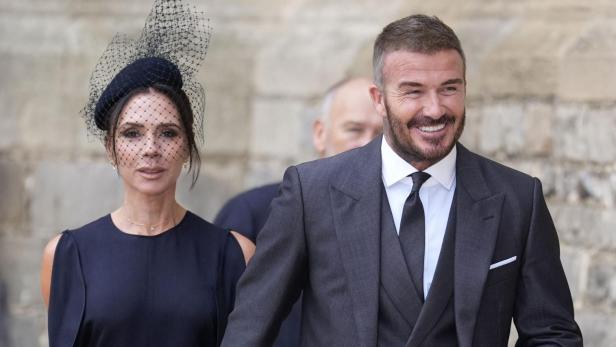 David und Victoria Beckham, elegant gekleidet, halten Händchen.