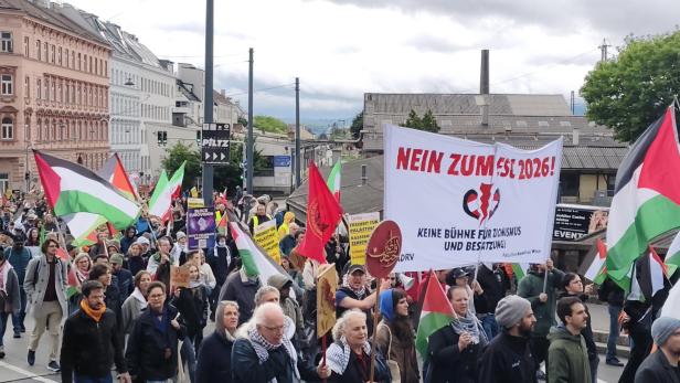 Demonstrierende Menschen mit palästinensischen Fahnen und Transparenten protestieren gemeinsam auf einer Straße.