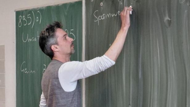 Lehrer schreibt auf Tafel