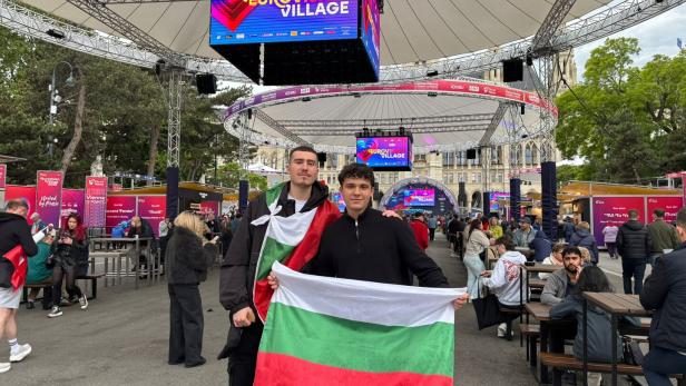 Zwei Männer halten eine bulgarische Flagge im Eurovision Village.