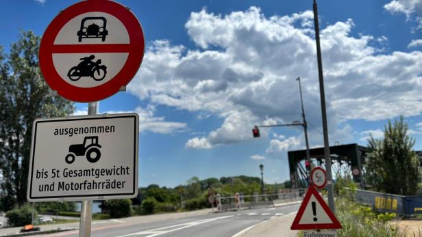 Verkehrsschilder verbieten Autos und Motorräder, ausgenommen Traktoren bis 5 Tonnen und Motorfahräder, mit Hinweis auf querende Fußgänger.