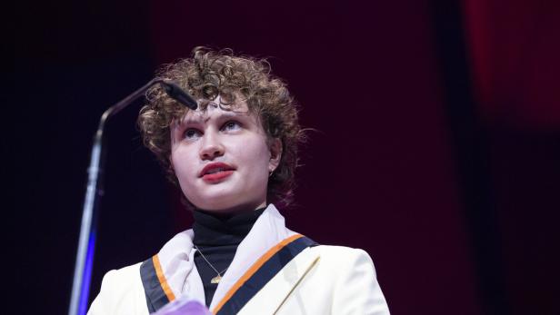 Luna Jordan mit lockigem Haar spricht am Rednerpult.