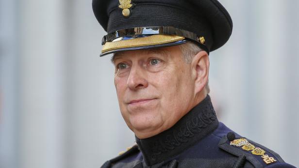 Andrew Mountbatten-Windsor in Uniform mit schwarzer Mütze und goldenen Verzierungen blickt zur Seite.