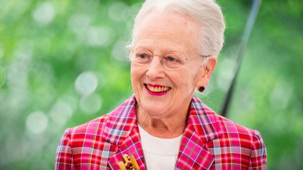Altkönigin Margrethe II. lächelt in einem karierten Blazer mit einer goldenen Brosche.