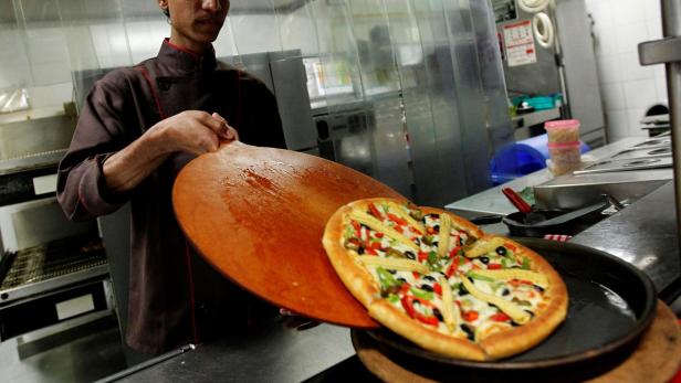 Mitarbeiter von Pizza Hut mit heißer Pizza