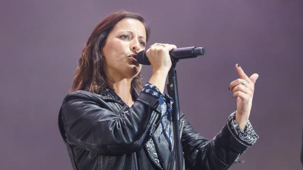 Stefanie Kloß mit Lederjacke performt mit Mikrofon auf der Bühne.