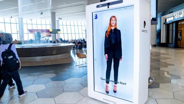 Interaktives Hologramm-Terminal mit virtueller Assistentin im Flughafen-Terminal.