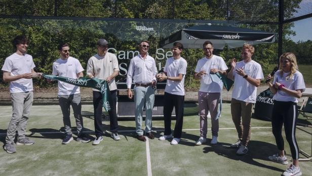 Acht Personen auf einem Padeltennis-Platz