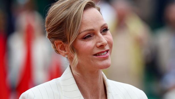 Fürstin Charlène lächelt in einem hellen Blazer mit dezentem Schmuck.
