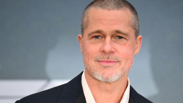 Brad Pitt mit kurzem, grau meliertem Haar und Bart trägt ein dunkles Jackett.