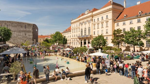 Viele Menschen und Familien genießen das bunte Fest rund um das Wasserbecken im MuseumsQuartier.