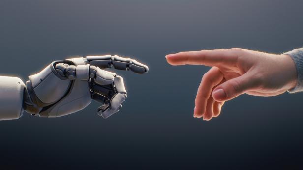 Eine menschliche Hand und eine Roboterhand nähern sich einander mit ausgestreckten Zeigefingern.