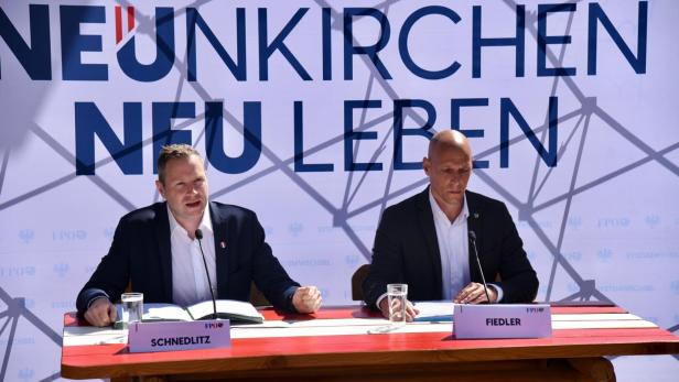 Zwei Männer vor einem Wahlplakat