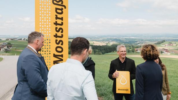 Mehrere Personen vor einem Schild mit der Aufschrift "Moststraße"