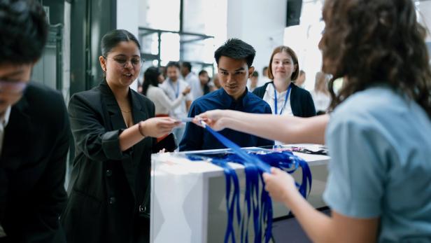 Attendees Registering and Collecting Lanyards at a Corporate Event Check-In Desk
