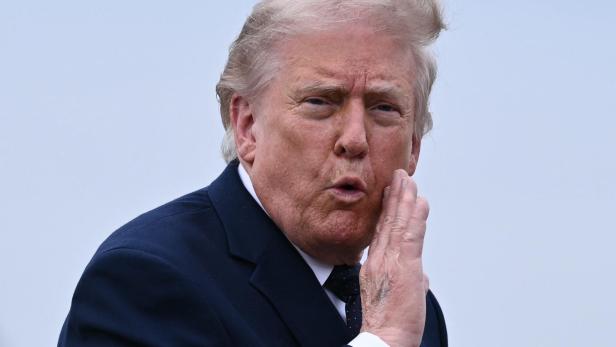 Donald Trump hält die Hand an sein Gesicht.