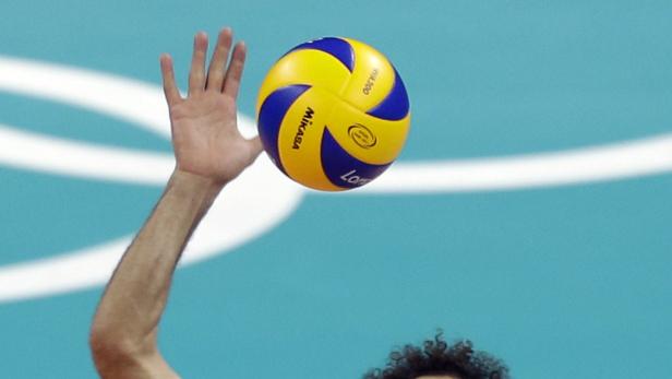 Ein Volleyballspieler schlägt einen gelb-blauen Mikasa-Volleyball.