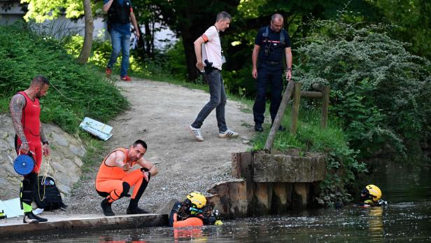 Taucher in Neoprenanzügen bereiten sich am Ufer eines Gewässers für einen Einsatz vor.