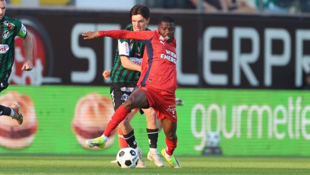 Ein Rapidler kämpft gegen einen Rieder um den Ball.